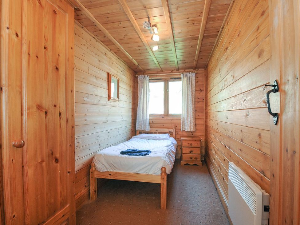 A bedroom with a bed and a wardrobe at Pencarrow in St Breward