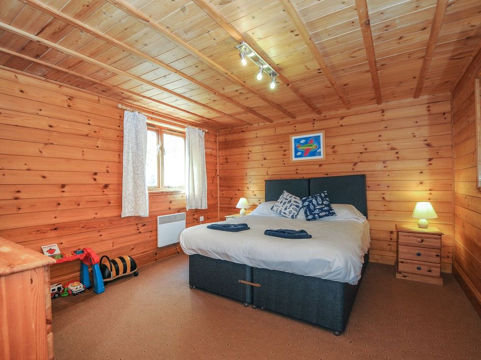 A bedroom with a bed and bedside tables at Pencarrow in St Breward
