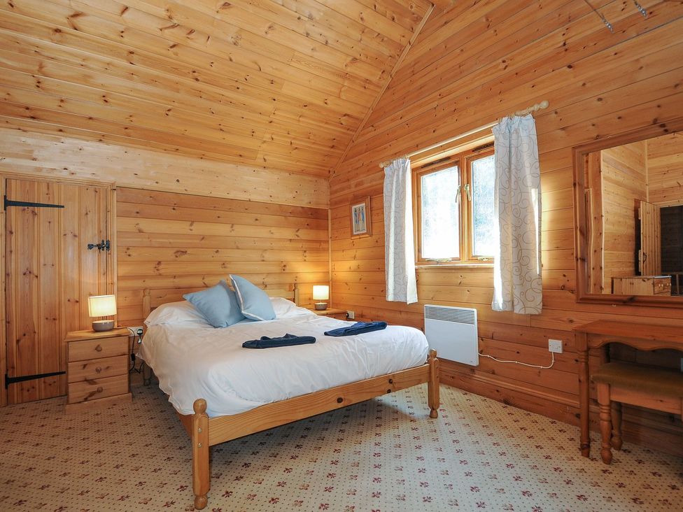 A bedroom with a bed and nightstand at Pencarrow in St Breward
