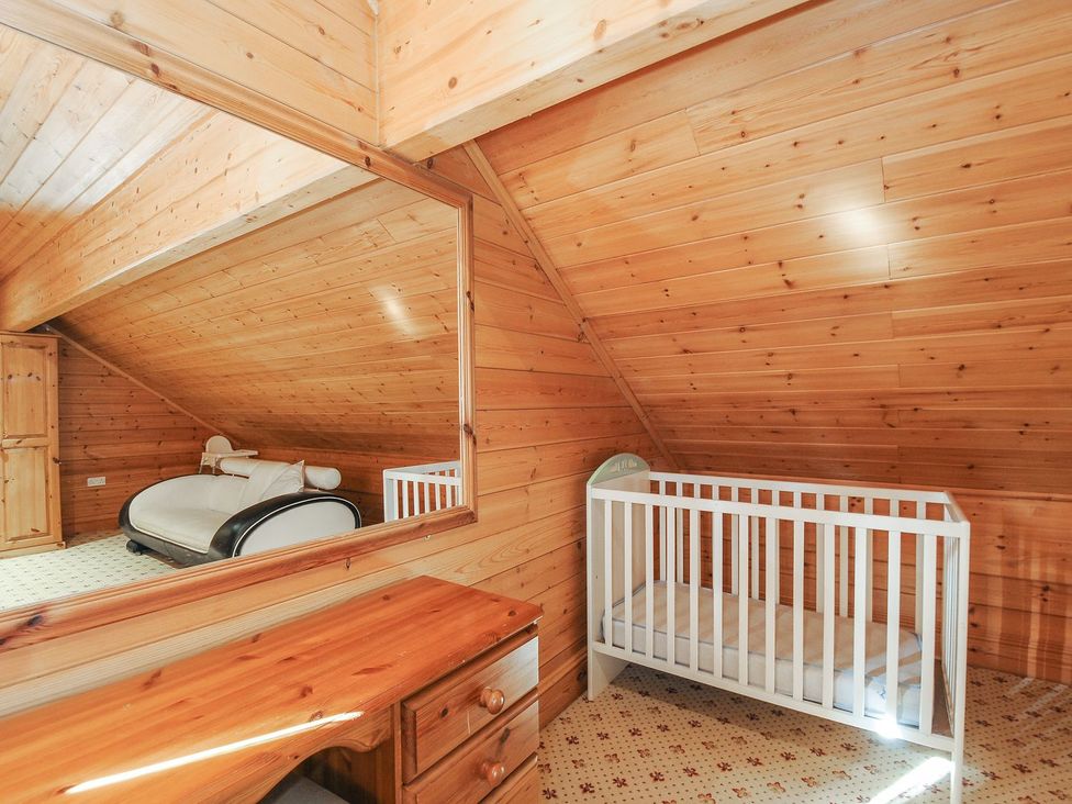 An attic with a crib and a sofa at Pencarrow in St Breward