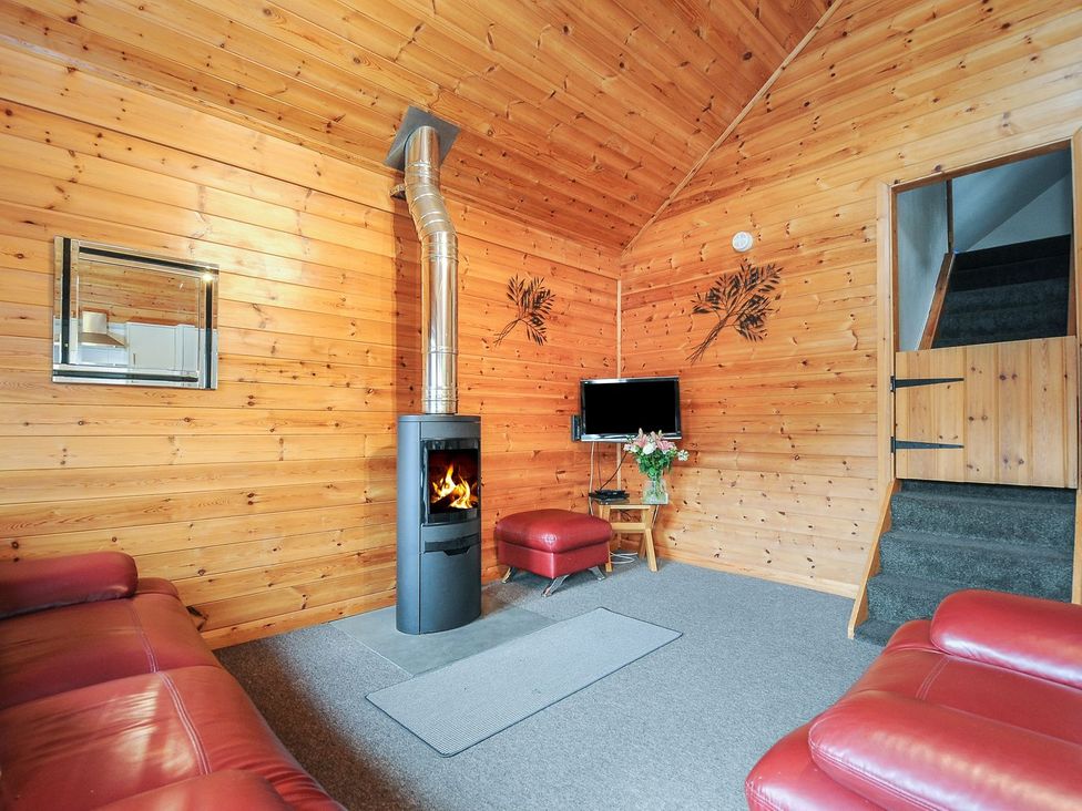 A living room with a fireplace and sofa at Trebah in St Breward