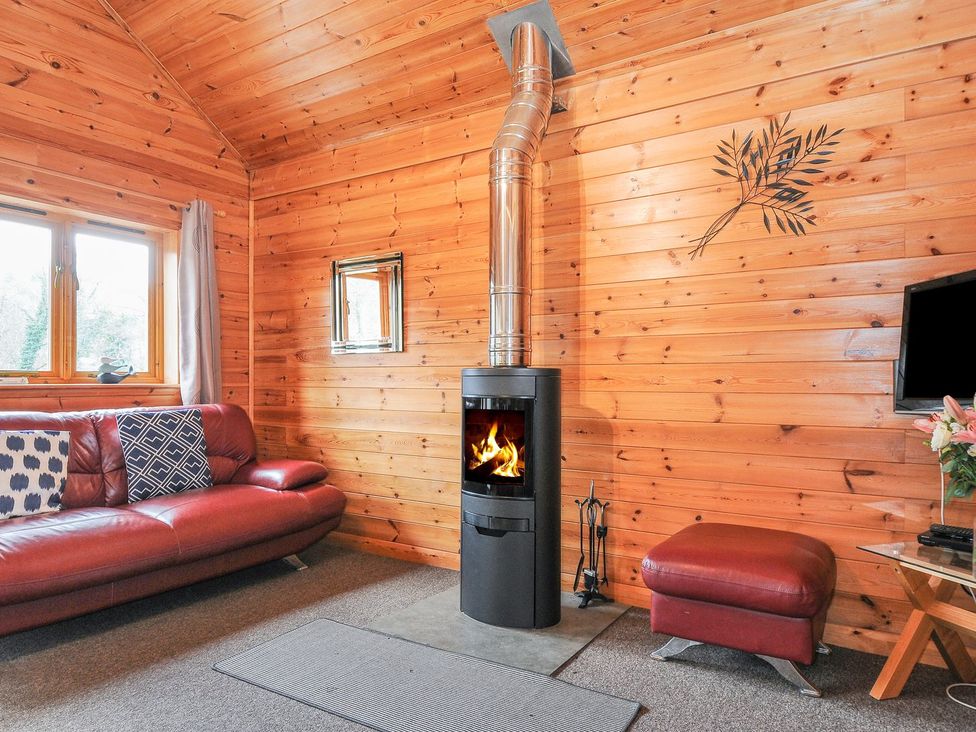 A living room with a fireplace and sofa at Trebah in St Breward
