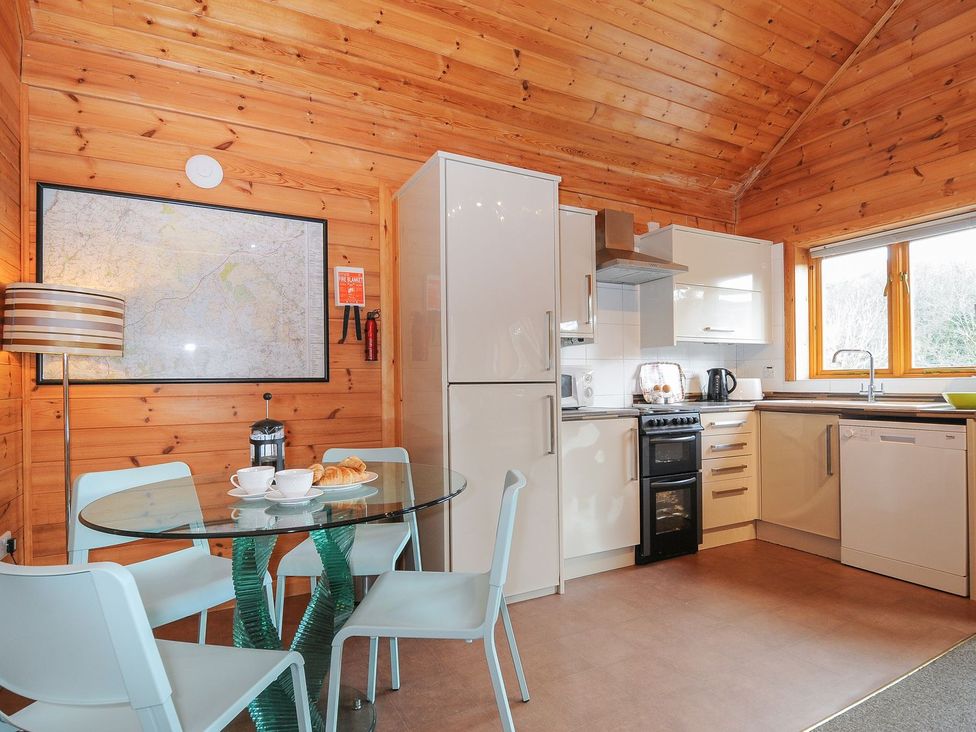 A kitchen with a glass table and four chairs at Trebah in St Breward