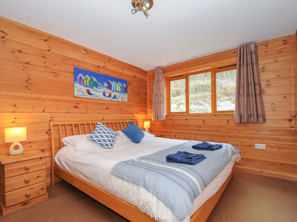 A bedroom with a bed and wooden furniture at Trebah in St Breward