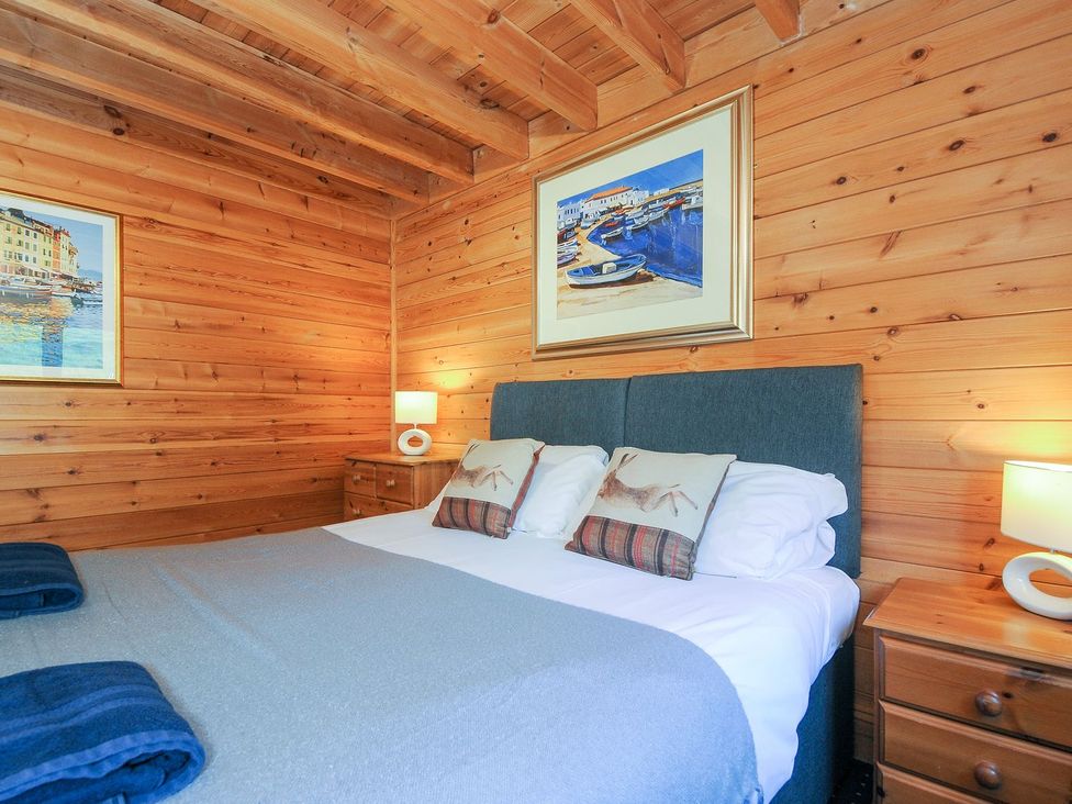 A bedroom with a bed and artwork on walls at Eden in St Breward