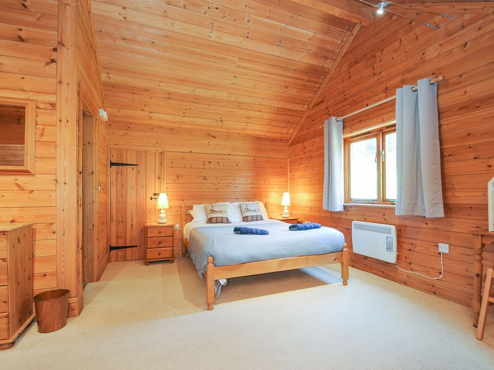 A bedroom with wooden walls and a bed at Eden St Breward