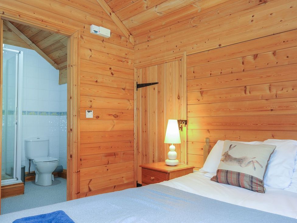 A bedroom with a bed and bathroom access at Eden in St Breward