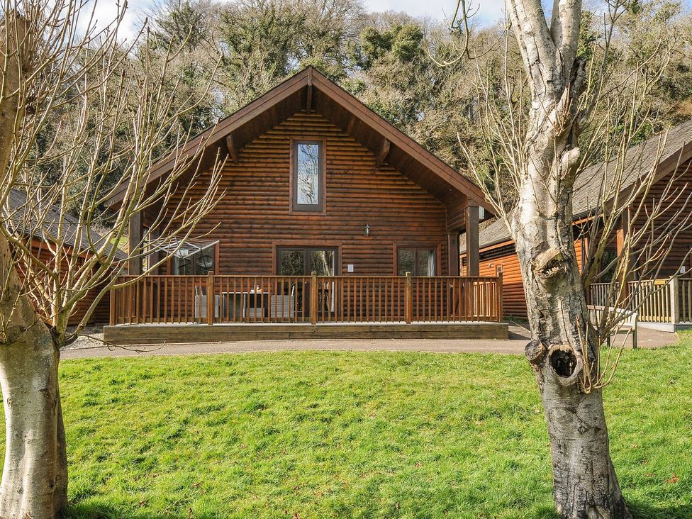 A log cabin with a deck and grass area at Heligan in St Breward