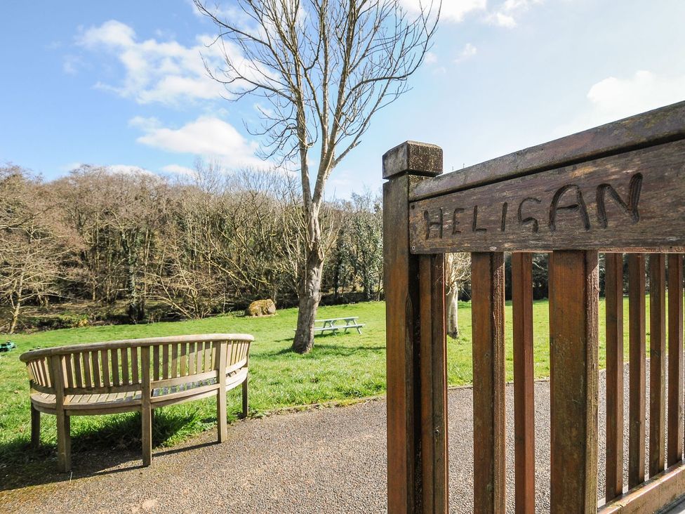 A picnic area with a wooden bench and gate at Heligan in St Breward