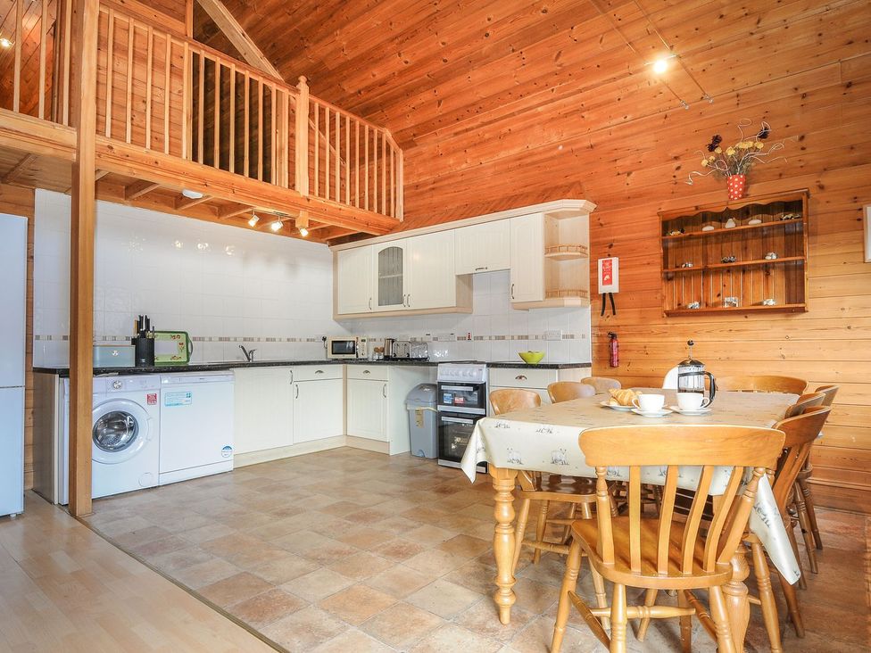 A kitchen with a table and chairs at Heligan in St Breward