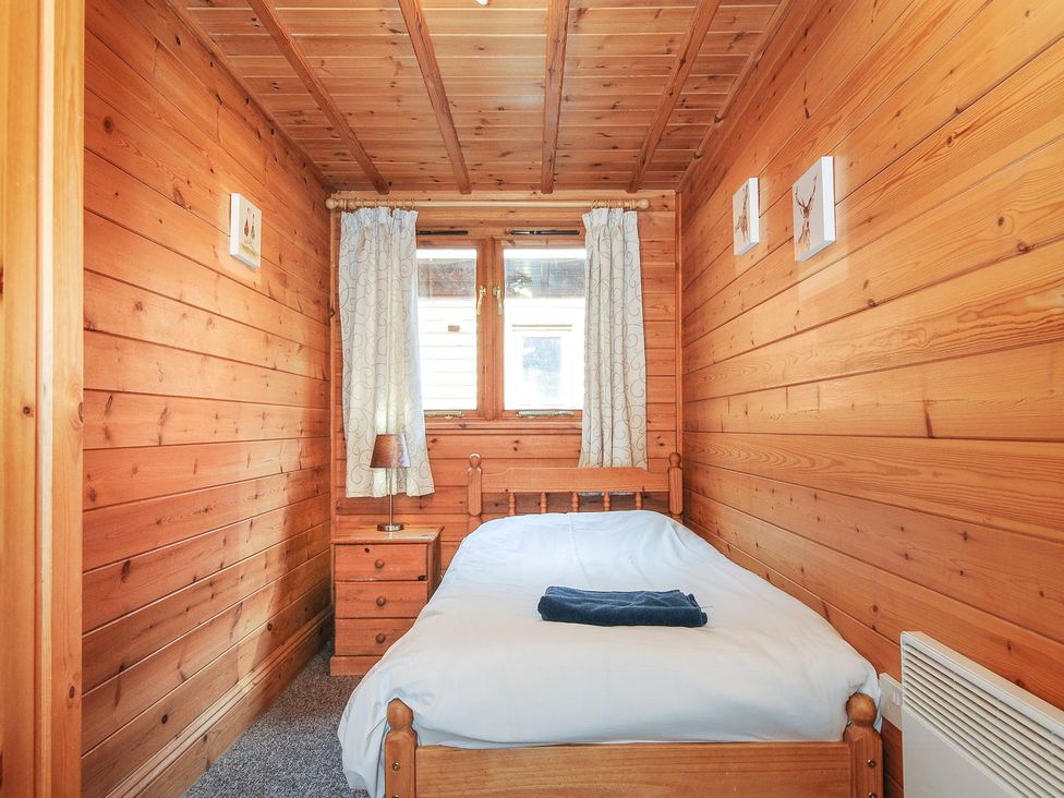 A bedroom with a bed and nightstand at Heligan, St Breward