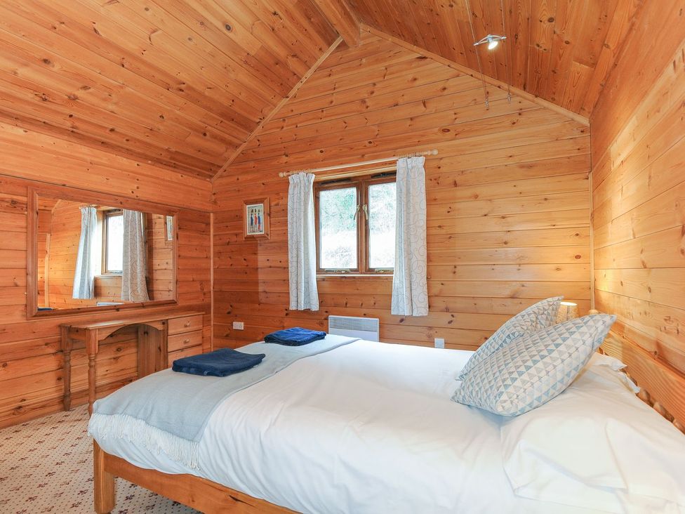 A bedroom with wooden walls and a bed at Heligan St Breward