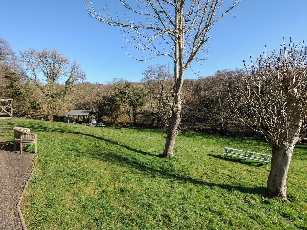 An outdoor area with a bench and picnic table at Heligan in St Breward