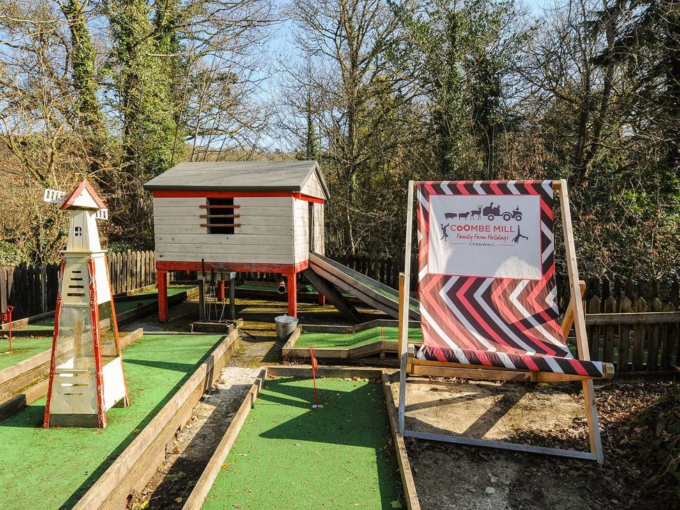 An outdoor playground with structures and signage at Coombe Mill in Cornwall