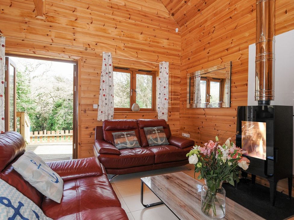 A living room with a sofa and fireplace at Polzeath in St Breward