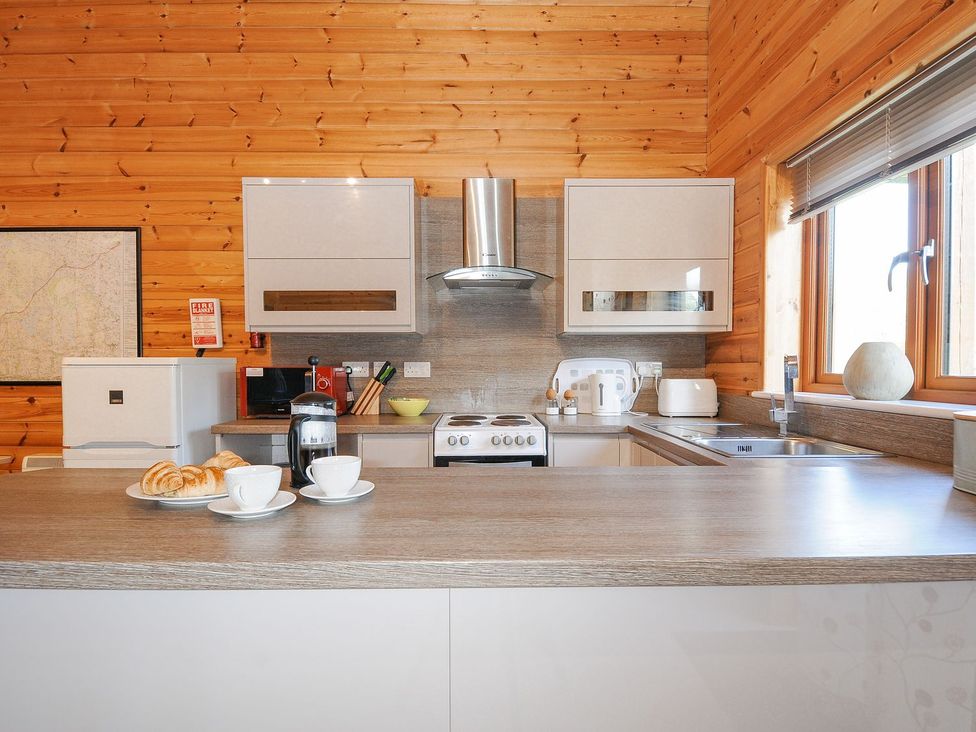 A kitchen with a fridge, cooker, and coffee maker at Polzeath in St Breward