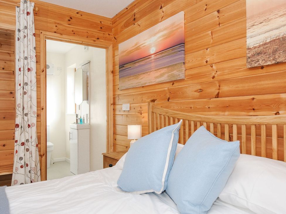 A bedroom with a bed and attached bathroom at Polzeath in St Breward