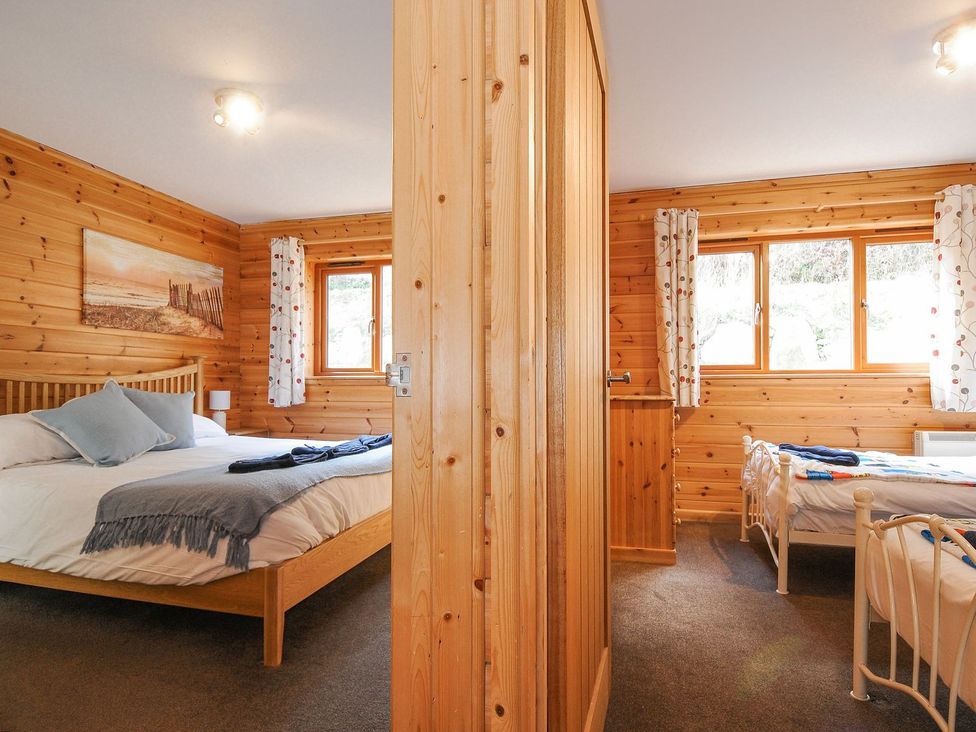 A bedroom with two beds and windows at Polzeath in St Breward