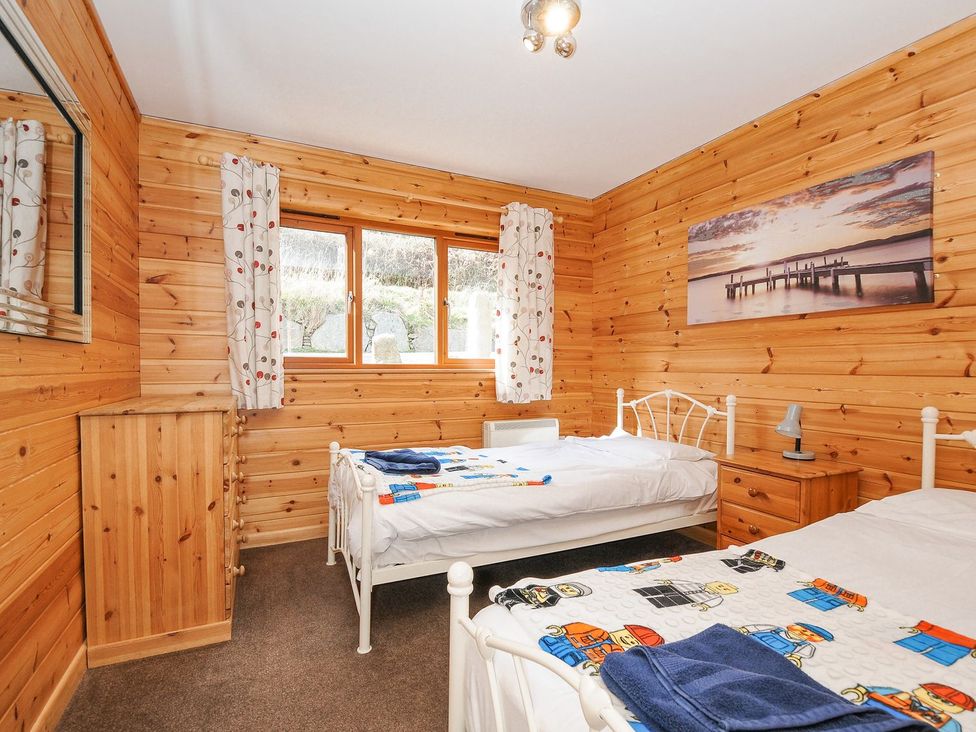 A bedroom with two beds and a nightstand at Polzeath in St Breward