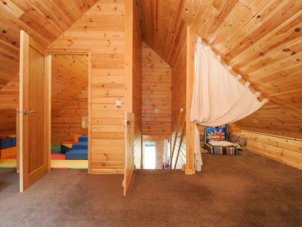 A loft with wooden walls and a soft play area at Polzeath St Breward