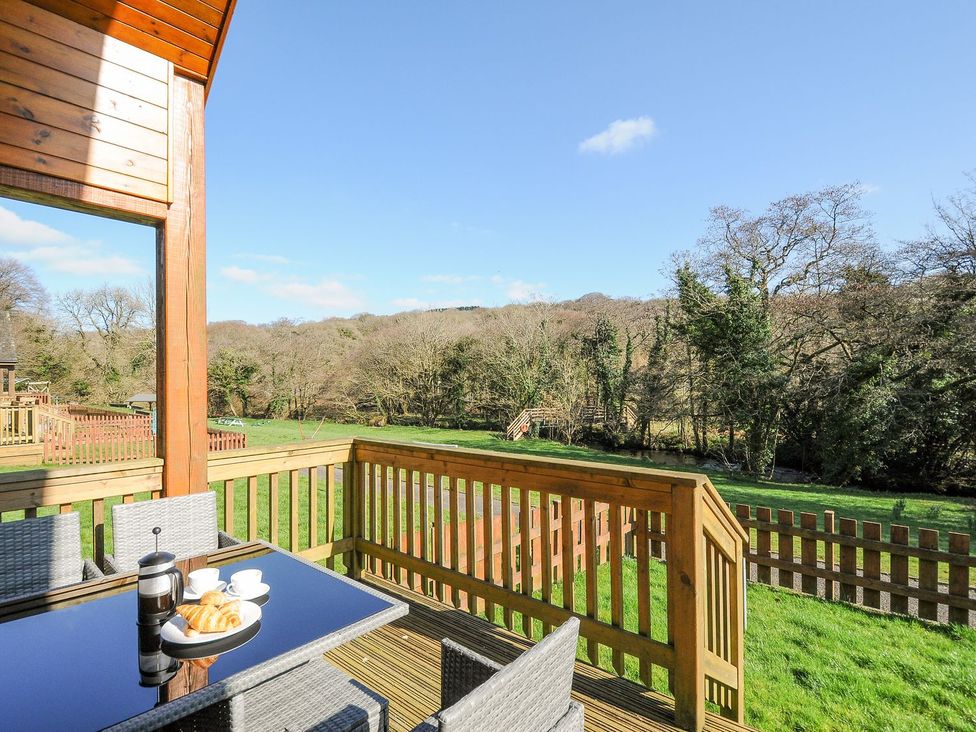 An outdoor patio with chairs and a table at Polzeath in St Breward