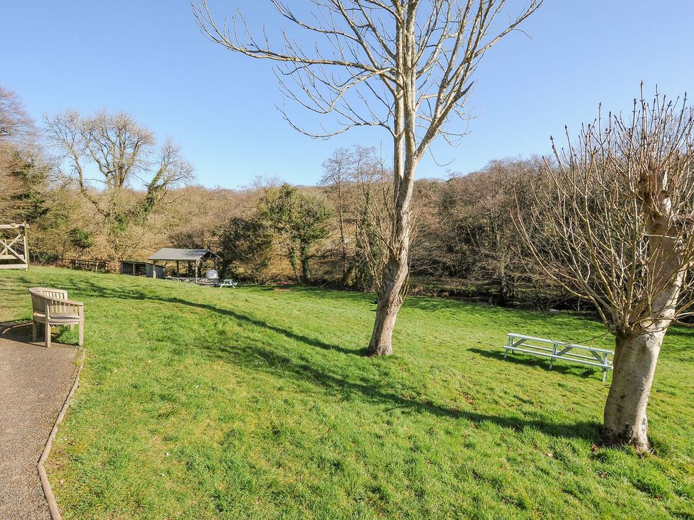 A garden area with a bench and a picnic table at Polzeath St Breward