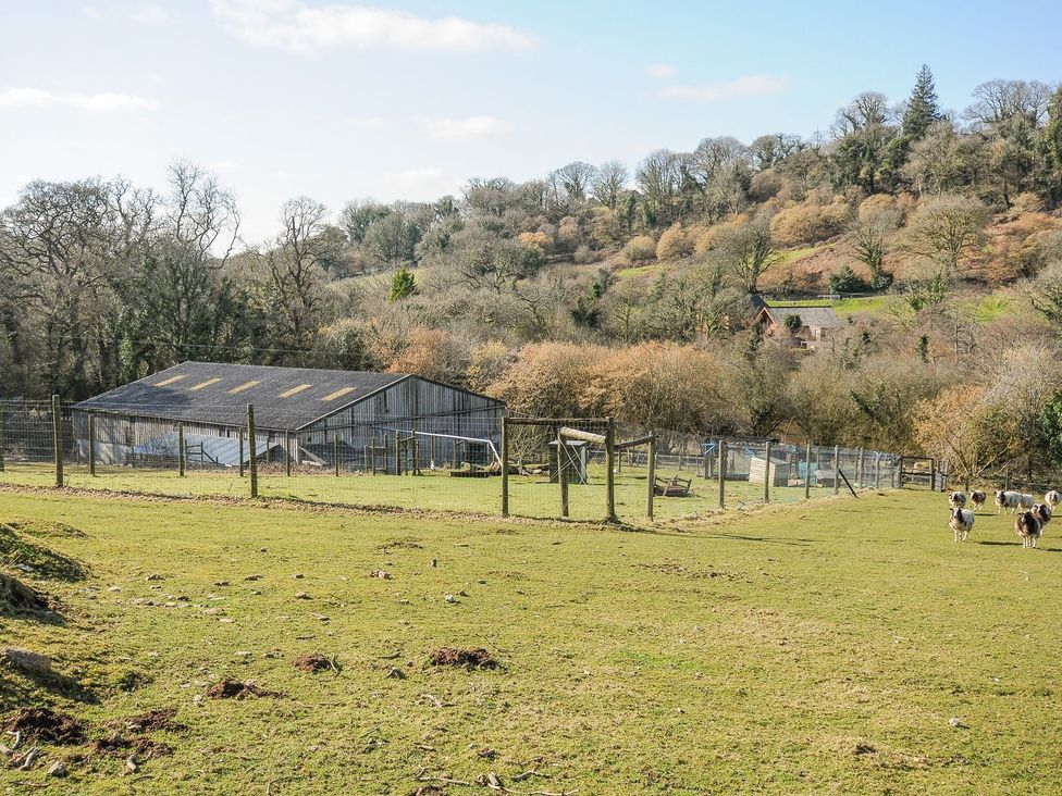 A farm with a barn, fenced area, and sheep at Polzeath in St Breward