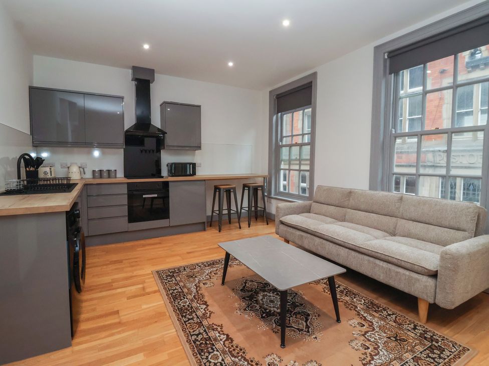 A kitchen with bar stools and a couch at Flat 9 in York