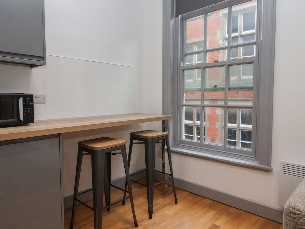 A kitchen with a wooden countertop and bar stools at Flat 9 in York