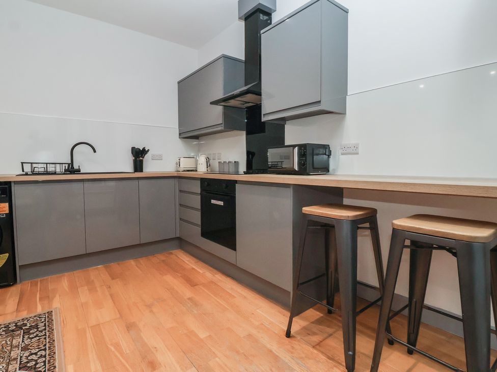 A kitchen with gray cabinets and appliances at Flat 9 in York
