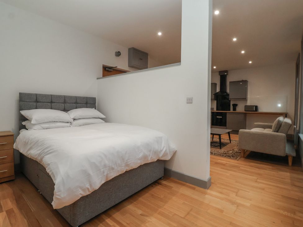 A bedroom with a bed and kitchen area at Flat 9 in York