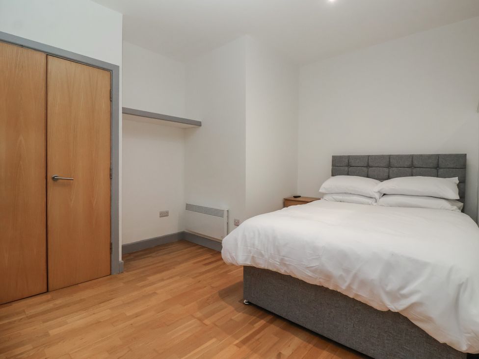 A bedroom with a bed and wardrobe at Flat 9 York
