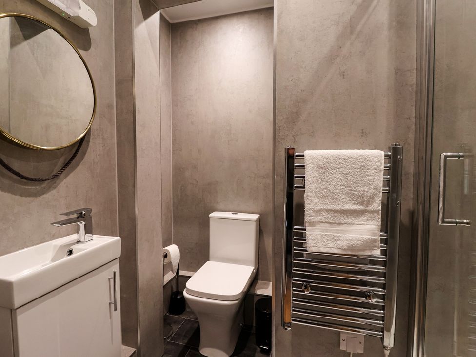 A bathroom with a toilet, sink, and towel rack at Flat 9 in York