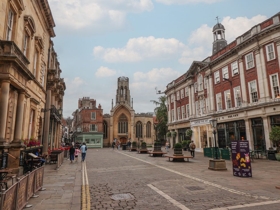 A street view with buildings and people at Flat 9 in York