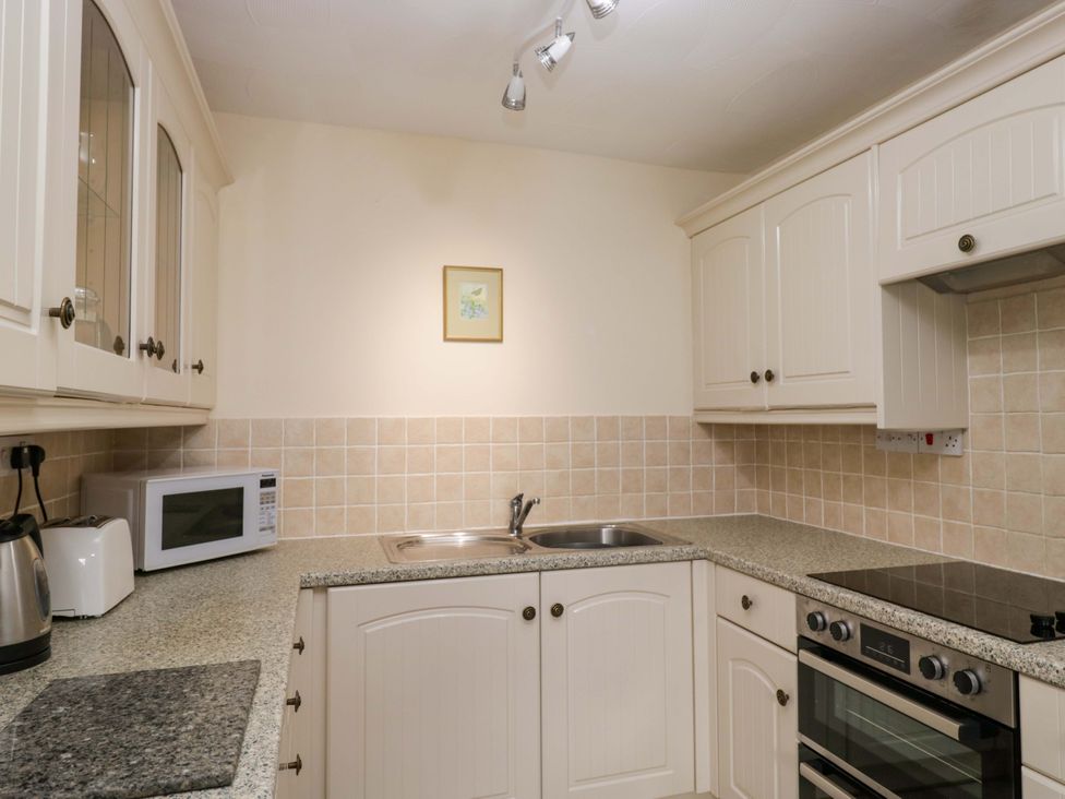 A kitchen with cabinets, sink and appliances at Buckbarrow Seascale
