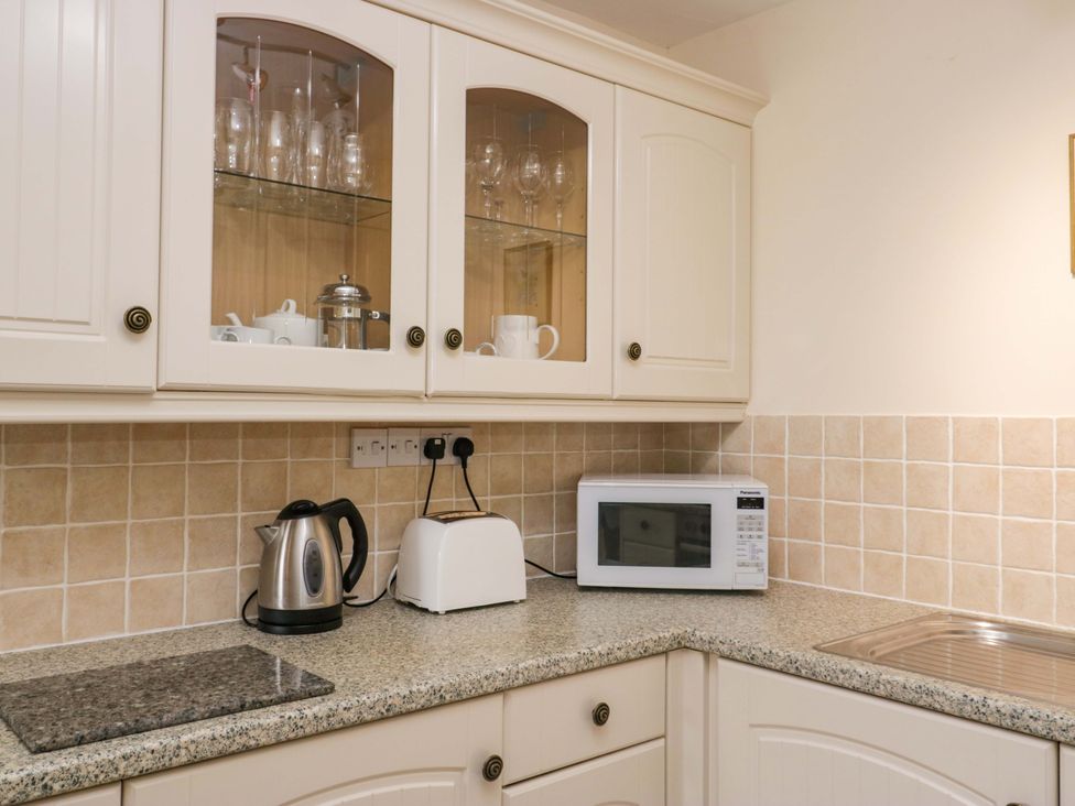 A kitchen with a microwave, kettle, and toaster at Buckbarrow in Seascale