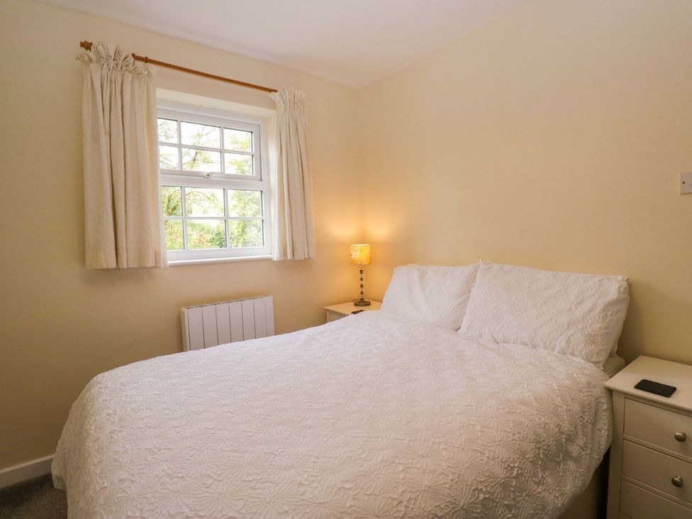 A bedroom with a bed and nightstand at Buckbarrow in Seascale