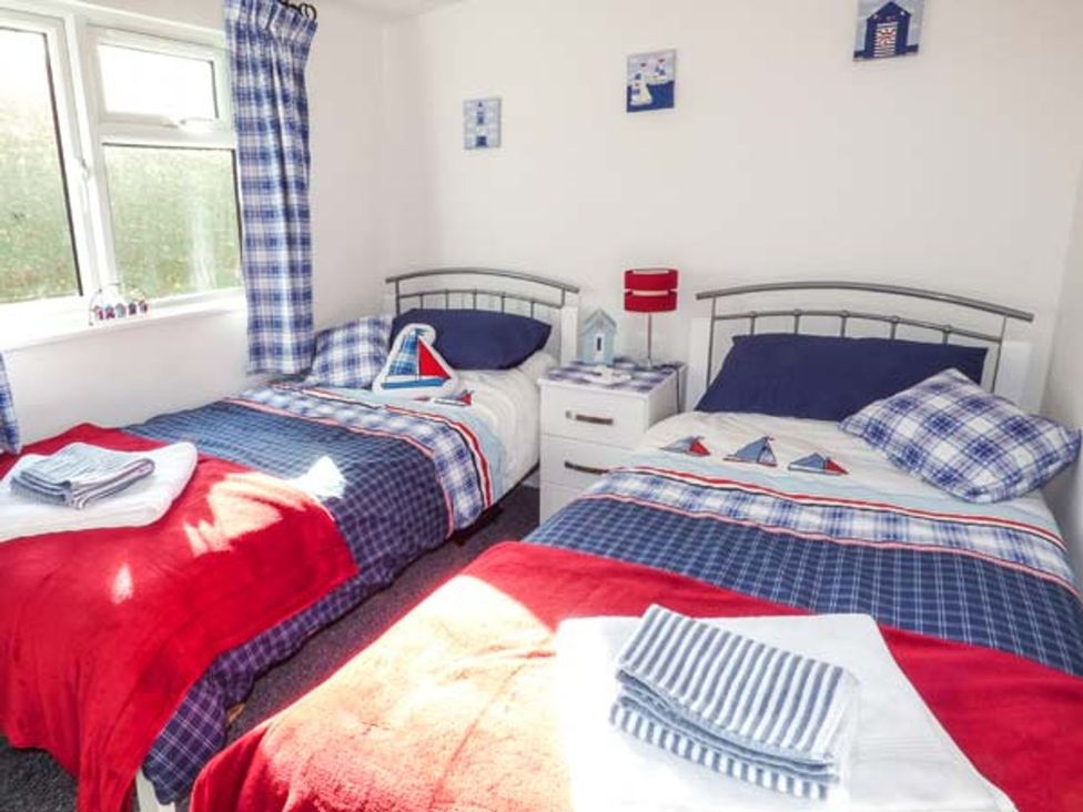A bedroom with two beds and a window at I C Lundy Too Bideford Bay Holiday Park near Clovelly