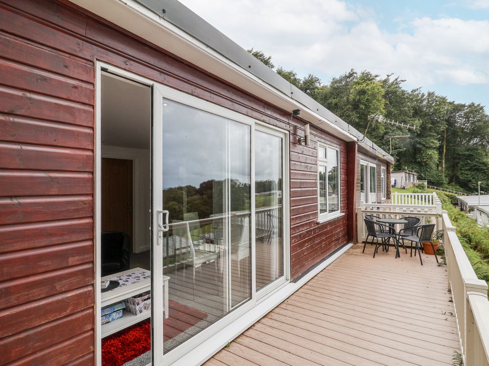 A deck area with seating and a glass door at I C Lundy Too in Bideford Bay Holiday Park near Woolfardisworthy