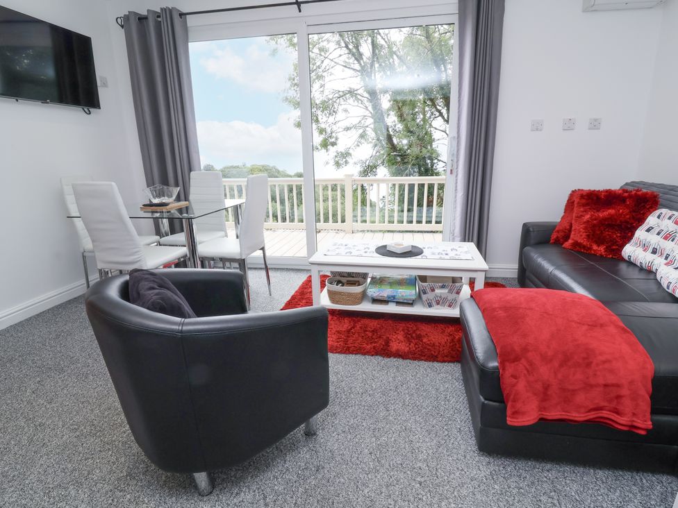 A living room with a sofa and dining area at I C Lundy Too Bideford Bay Holiday Park near Woolfardisworthy