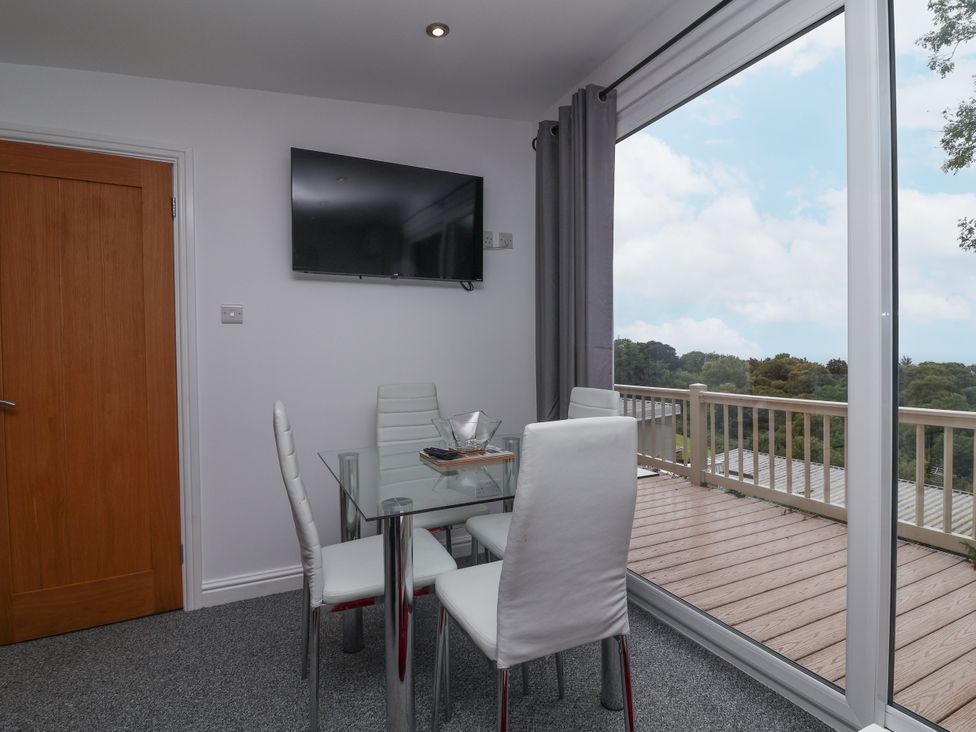 A dining room with a table and chairs at I C Lundy Too Bideford Bay Holiday Park near Woolfardisworthy