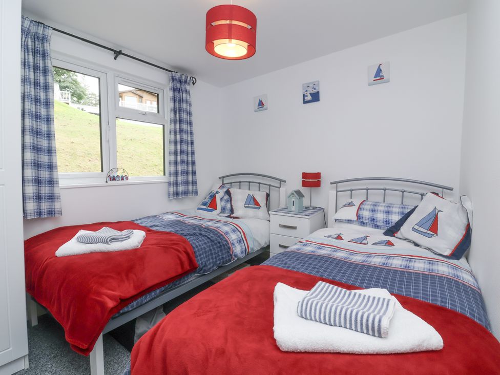 A bedroom with two beds and a window at I C Lundy Too Bideford Bay Holiday Park near Woolfardisworthy