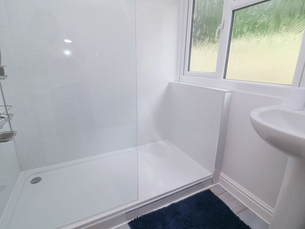 A bathroom with a shower and a sink at I C Lundy Too Bideford Bay Holiday Park near Woolfardisworthy