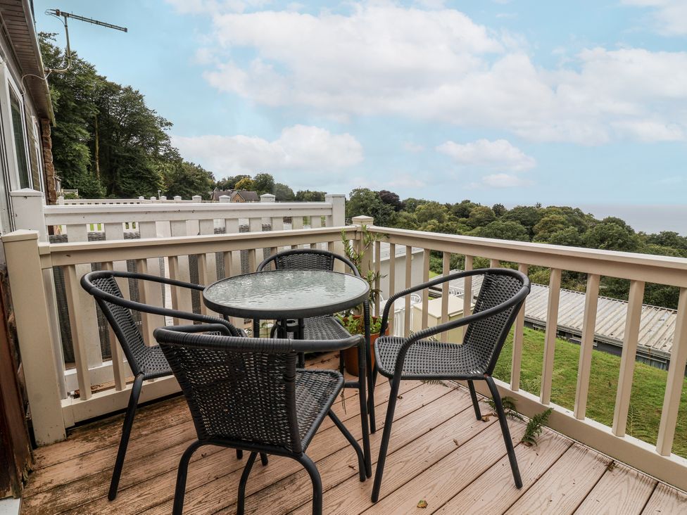 A balcony with a table and chairs at I C Lundy Too near Bideford Bay Holiday Park