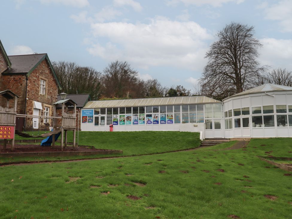 An outdoor view of a building and playground at I C Lundy Too in Bideford Bay Holiday Park near Woolfardisworthy