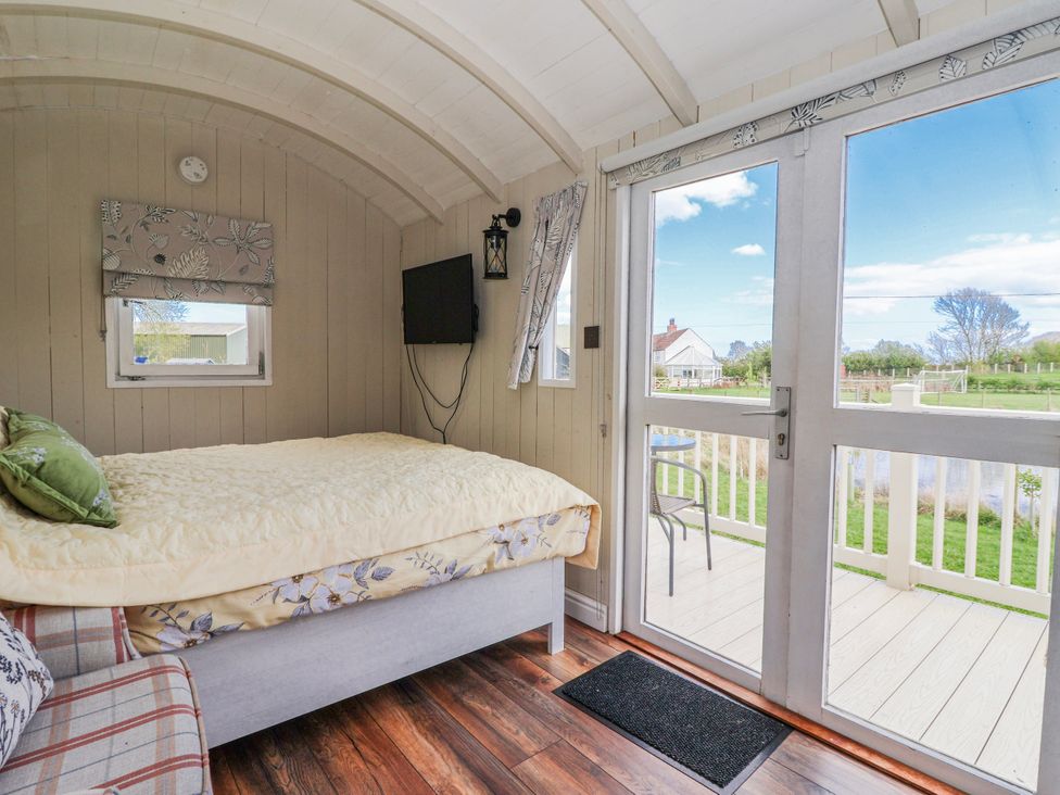 A bedroom with a bed and couch at The Dragonfly in Bewholme near Hornsea