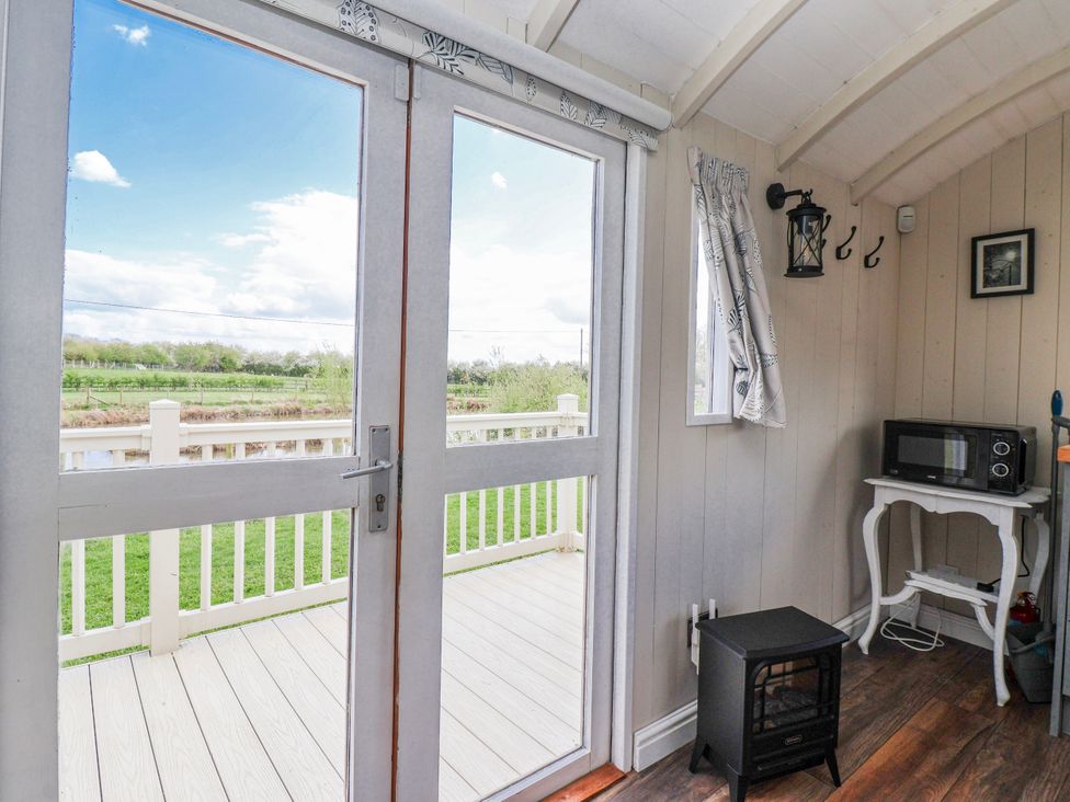 A room with a door and window overlooking the landscape at The Dragonfly in Bewholme near Hornsea