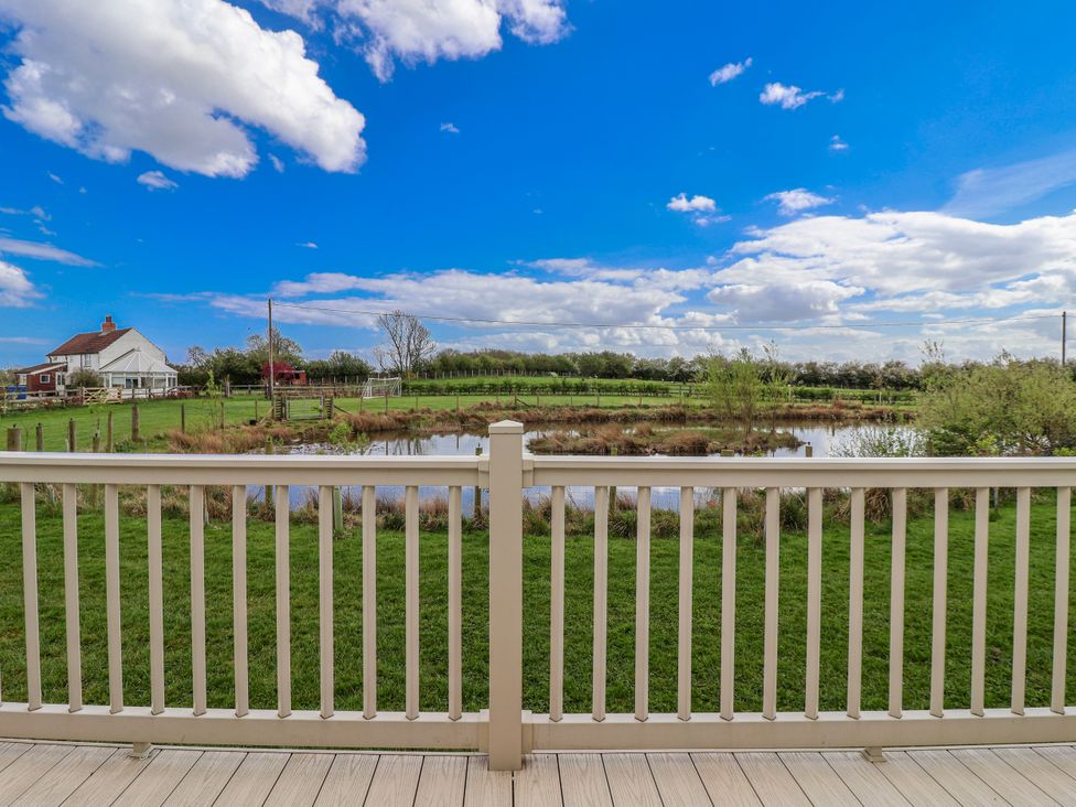 An outdoor view with a fence and a pond at The Dragonfly in Bewholme near Hornsea