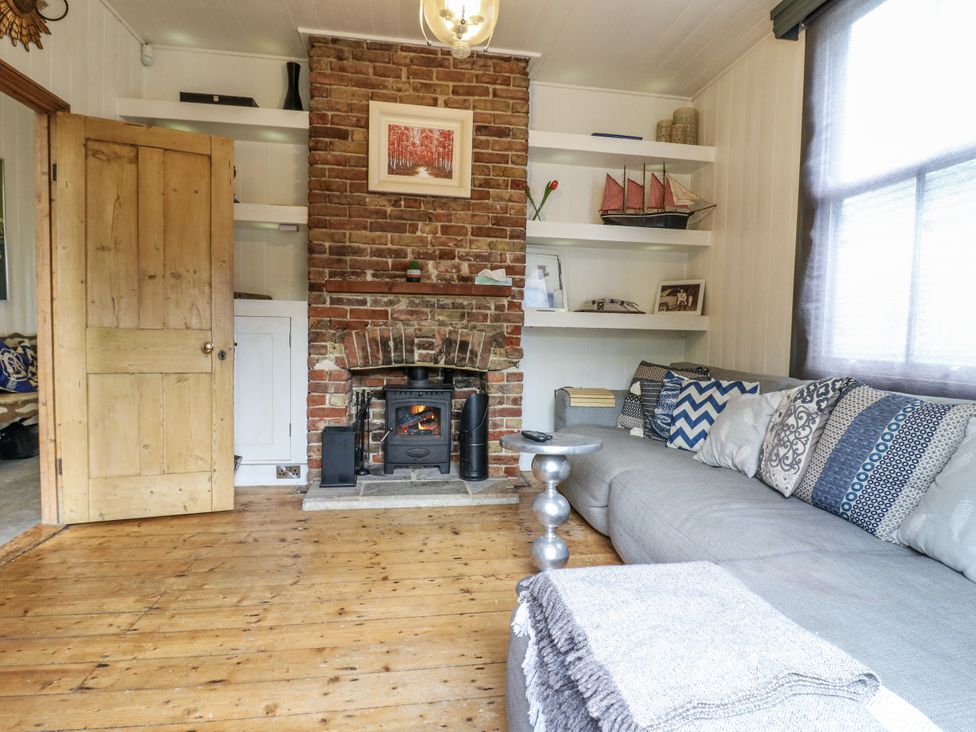 A living room with a fireplace and shelves at 14 Marine Terrace in Whitstable