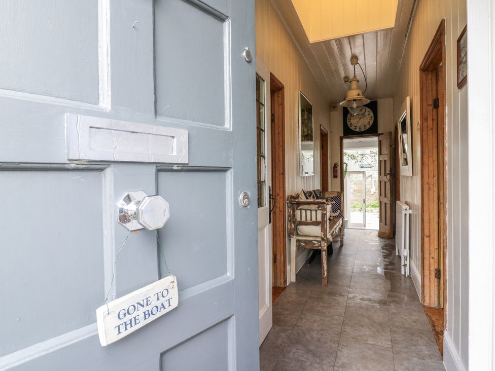 A hallway with a door and clock at 14 Marine Terrace in Whitstable